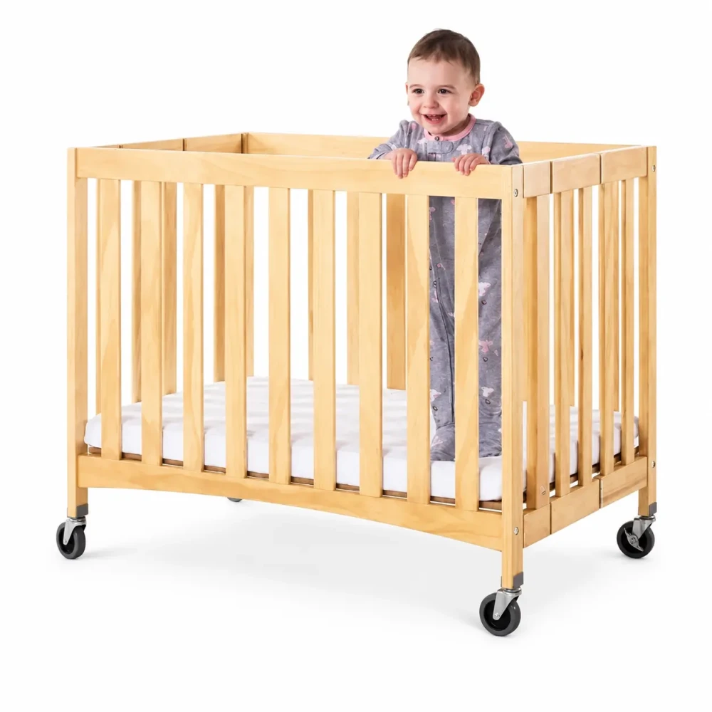 Foundations Natural Compact Slatted Wood Folding Crib with Oversized Casters and 2 Inch InfaPure Mattress